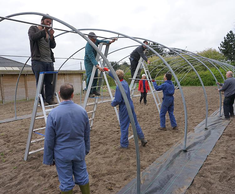 Cliënten helpen met de opbouw van de zaaitunnel.